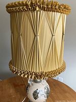 Full view of lamp with shade showing pleated fabric and ceramic base