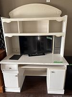 Front view of desk with hutch, showing drawers, cabinets, keyboard tray, shelves, media slots