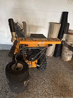 Front view of Yard King snowblower showing auger housing, control handles and extra tire