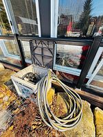 Overall view of Yardworks plastic hose reel box with open lid and coiled hose