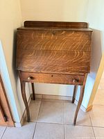 Front view of closed secretary desk showing overall form and lower drawer