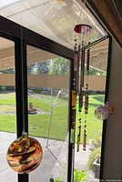 Wind chime hanging beside two glass orbs to show grouping and scale