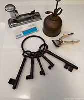 All items grouped: ring of skeleton keys, stapler with staples box, oil can, hair trimmer