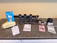 All items laid out: Panasonic phone system, AT&T Trimline phone with box, two cameras with manuals and accessories