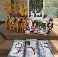 Full lot view showing wooden reindeer, framed deer pieces, Santa, nutcracker, snow globe, tray with spreaders, and snowman plaque