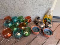 Group shot of all items: glass holders, oil lamps, citronella candles, fuel bottle