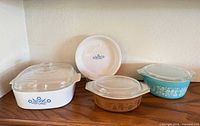 All four dishes with lids and pie plate displayed on shelf
