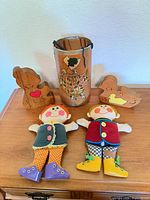 Group shot of both dolls, two wooden puzzles, and cylindrical container