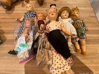 Group of eight dolls laid out on table showing sizes and outfits