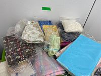Overview of assorted bagged fabric remnants in box