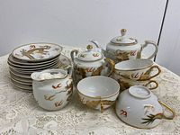 Entire Cherry China dragon tea set displayed on lace cloth
