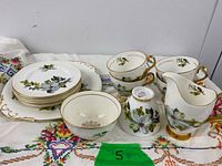 Full set laid out on cloth showing platter, bowls, cups, saucers