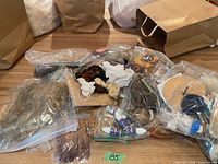 Overview of wigs, hats, adhesive in bags on table