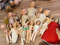 Group shot of all dolls lying on floor showing quantity, size range and condition