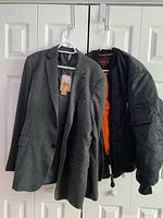 Two jackets hanging: black SGS bomber jacket and grey Paul Jones blazer