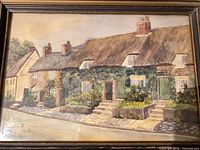 Front view of framed watercolor depicting cottages