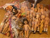 Overview of all zip bags filled with small plastic dolls and parts