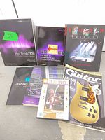Group shot of three Pro Tools books, Rush Tribute book, Guitar Magazine and Victor Wooten DVD