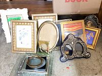 Group view of nine assorted frames, various shapes and finishes, plus loose glass panels