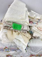 Stack of white and cream lace and embroidered linens