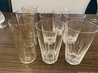 Group of eight crystal highball glasses showing three striped and five cut-pattern