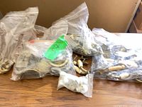 Bags of assorted brass and ceramic hardware on table