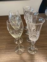 Six of the seven wine glasses showing two styles: heavy cut-crystal goblets and thin etched glasses