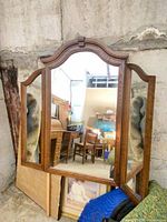 Front view showing tri-fold mirror open with wood frame and hinges