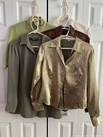 Front view of five dress shirts on hangers showing colours and styles