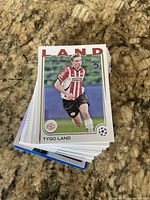 Stack of soccer trading cards with Tygo Land rookie card on top