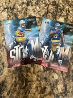 Front view of both rookie By Storm cards showing players, team uniforms, RC shield and Absolute branding