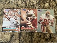 Front view of three 1991 Pro Set football cards: Dan Marino, Joe Montana, Jerry Rice