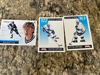 Three Wayne Gretzky Score brand hockey trading cards on countertop