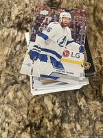 Stack of hockey trading cards topped by Braydon Coburn Tampa Bay Lightning Upper Deck card, showing quantity and condition