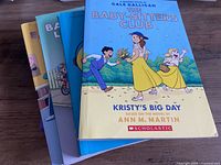 Stack of five children’s paperback books showing cover of The Baby-Sitters Club Kristy’s Big Day and partial covers of others