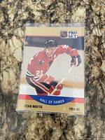 Front view of Stan Mikita Hall of Famer NHL Pro Set card in sleeve on granite surface