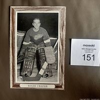 Front view of Beehive Group 3 photo showing Roger Crozier in goalie gear with woodgrain border and caption
