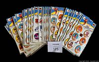 Front view of all 29 sealed packs fanned out displaying player stickers