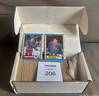 Box with full set of cards, Sakic and Leetch cards displayed on top, MaxSold lot card visible