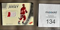 Front of card showing player image, jersey swatch, card title, Chelios name