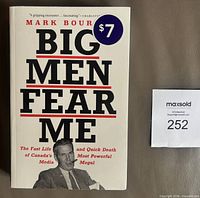 Front cover of softcover book showing title, author, price sticker and photo