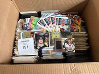 Open box filled with stacked McDonalds hockey trading cards, Maxsold lot card visible