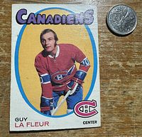 Front of Guy Lafleur rookie card beside coin for scale