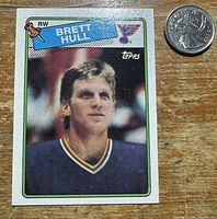 Front of Brett Hull Topps rookie card beside quarter for scale