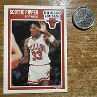 Front of Scottie Pippen Fleer #23 card with coin for scale
