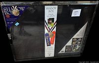 Front of factory-sealed shadow box packaging