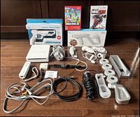 Full lot layout displaying console, controllers, cables, games, microphones, sensor bar, camera and sealed accessories