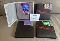 Four NES cartridges with protective sleeves, Tetris fully visible in clear case, others partially in black sleeves