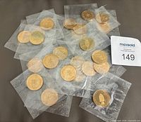 Group of sealed coins spread out showing both sides and sealed packaging