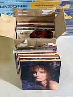Open cardboard box and loose stack showing quantity and Barbra Streisand Wet cover